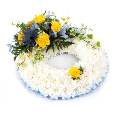 Wreath SYM-319 - This white massed wreath is finished with a blue and yellow spray for an extra special tribute.